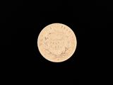 l'image d'une pièce de monnaie posée sur une surface noire, sur fond noir