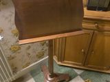a wooden music stand in the corner of a room