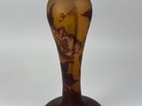 an old fashioned lamp with a gold and brown glass shade on it