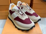 Une paire de baskets blanches et bordeaux se trouve sur une boîte