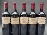 four bottles of wine are lined up on a table