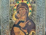 the icon of the mother of jesus is displayed in a silver frame