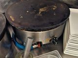 une casserole sale posée sur la cuisinière dans une cuisine