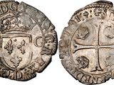 a silver coin with a cross on the front and a shield on the back