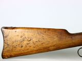 an old rifle with a wooden barrel on a white background
