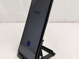 a close up of a cell phone on a stand on a white surface