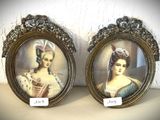 Deux portraits encadrés, représentant une femme et un homme, sont exposés