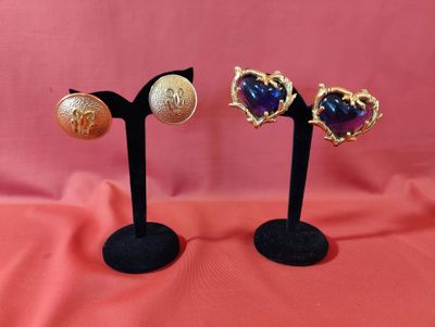 deux paires de boucles d'oreilles en forme de coeur sur des supports noirs sur fond rose