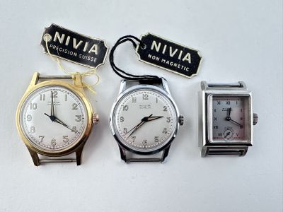 trois montres et un porte-clés sont posés sur une surface blanche