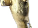 a gold figurine of a hand holding a cell phone