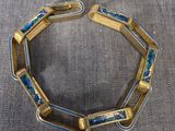 un gros plan sur un bracelet en or orné de perles de verre bleues