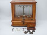 une vitrine en bois contenant une balance et quelques autres objets