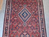 a red and blue rug with a diamond design on it