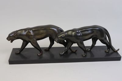 figurine en bronze représentant deux guépards marchant sur un socle noir