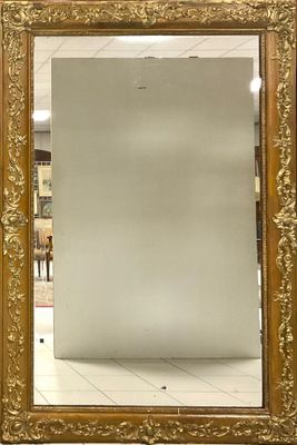 un miroir à cadre doré dans un magasin au sol blanc