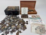 beaucoup de pièces et une boîte remplie d'argent sur la table