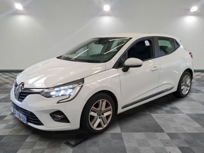 une voiture blanche est garée dans une pièce au sol à carreaux