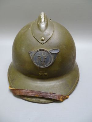un vieux casque militaire orné d'une croix sur le côté