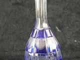 a blue glass bottle with a clear top on a black surface