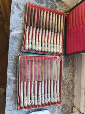 beaucoup d'argenterie dans un coffret rouge posé sur une table