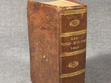 an old book sitting on top of a table on a gray surface