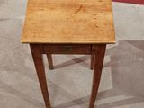 a small wooden table with a drawer on it