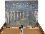 une image représentant une boîte en carton avec, en arrière-plan, une peinture représentant un pont