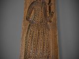 a carved plaque with a woman holding a flower in her hand