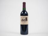 une bouteille de vin rouge posée sur une table blanche