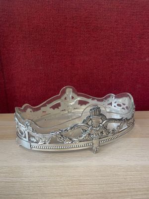 a silver plate on a wooden table with a red background