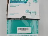 un tube de dentifrice Elmex vide posé sur une table