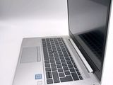 a silver laptop computer sitting on a white surface