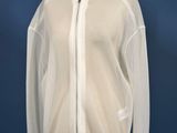 the white jacket is on a mannequin stand against a blue wall