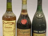 trois bouteilles de vin sont alignées sur une surface blanche