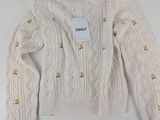un pull blanc avec des boutons et une étiquette
