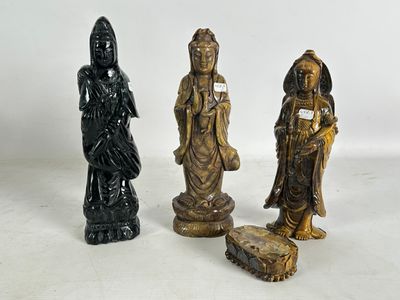 trois figurines asiatiques posées sur une surface blanche