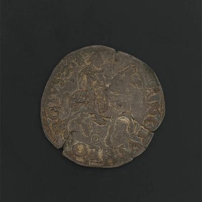 a close up of a coin on a black surface with a black background