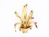 une photo d'une broche en or sertie de pierres roses
