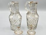 two clear glass vases sitting next to each other on a white surface