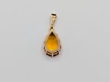 a yellow gold pendant with a tear shaped stone in the center