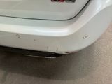 a close up of a white car with a sticker on it ' s bumper