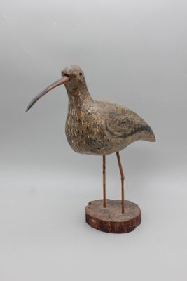 un petit oiseau posé sur un socle en bois