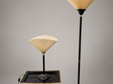 une paire de lampes en forme d'éventail, noires et dorées, montées sur un pied