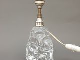une bouteille en verre avec une poignée blanche posée sur une table