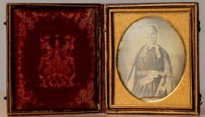 Photo daguerréotype. Femme à la coiffe tenant un livre.