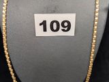 un gros plan d'un collier sur un mannequin, avec une étiquette de prix