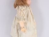 a close up of a doll in a white dress on a white background