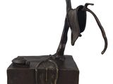 une image représentant une statue en bronze d'un oiseau posé sur un tronc