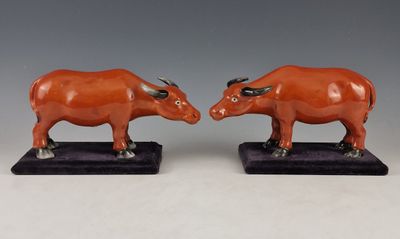deux figurines représentant des taureaux aux cornes dressées, posées sur un socle noir