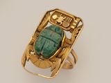 an image of a gold ring with a green stone in the center